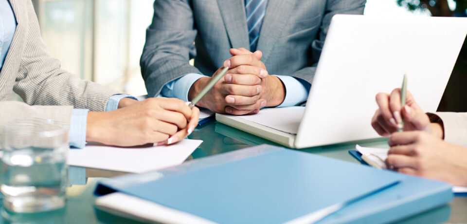 Close-up of hands of boss at workplace with laptop and hands of two females near by