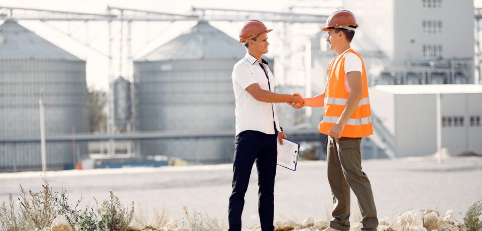 Engineers near the factory. Mtn in a helmet. Inspector looks at the building.